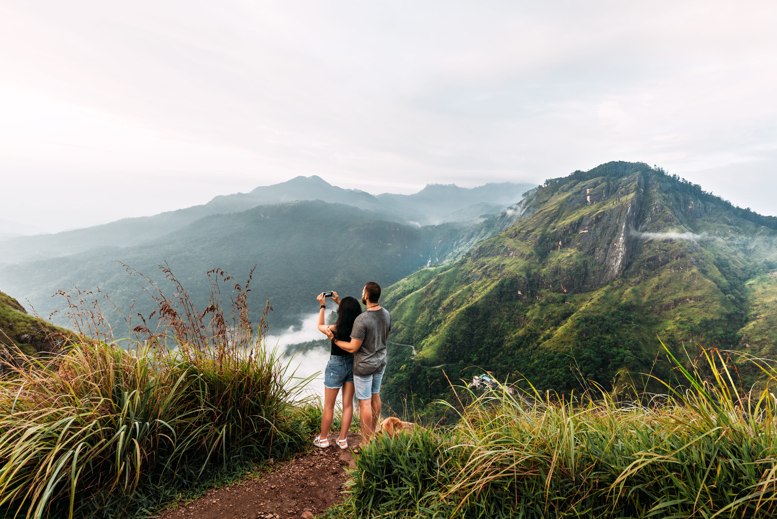 The couple travels the world. A couple in love travels to Sri Lanka. The couple travels to Asia. Man and woman meet the dawn in the mountains. Vacation in Asia. Happy couple in the mountains.